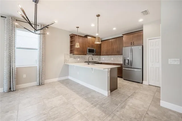 a kitchen with a sink a counter and chairs