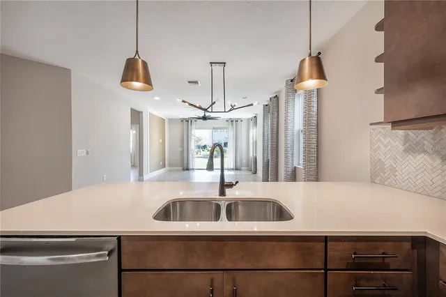 a kitchen with stainless steel appliances granite countertop a sink a stove and a wooden cabinets