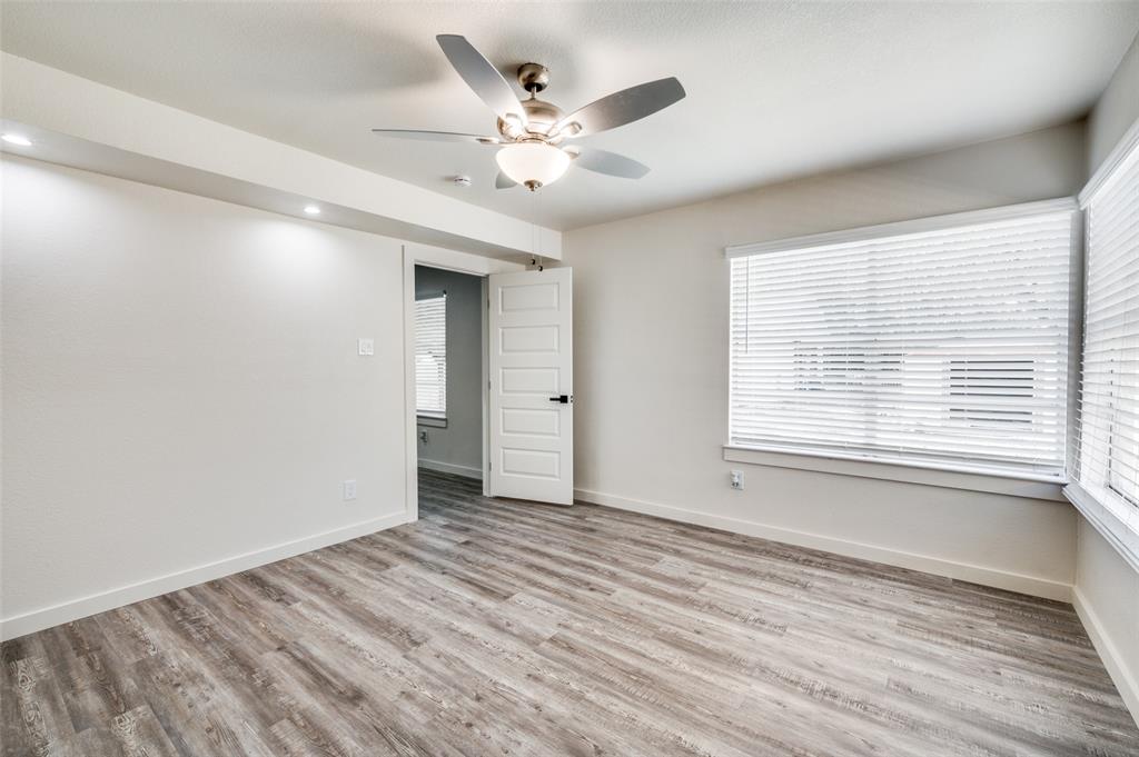 733 Southeast 3rd Street Grand Prairie, TX 75051 - Photo 12 of 24 Unfurnished room with light wood finished floors and ceiling fan