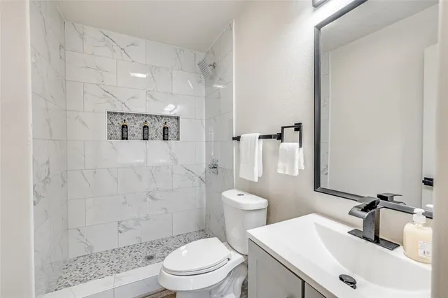 a bathroom with a sink a toilet and shower