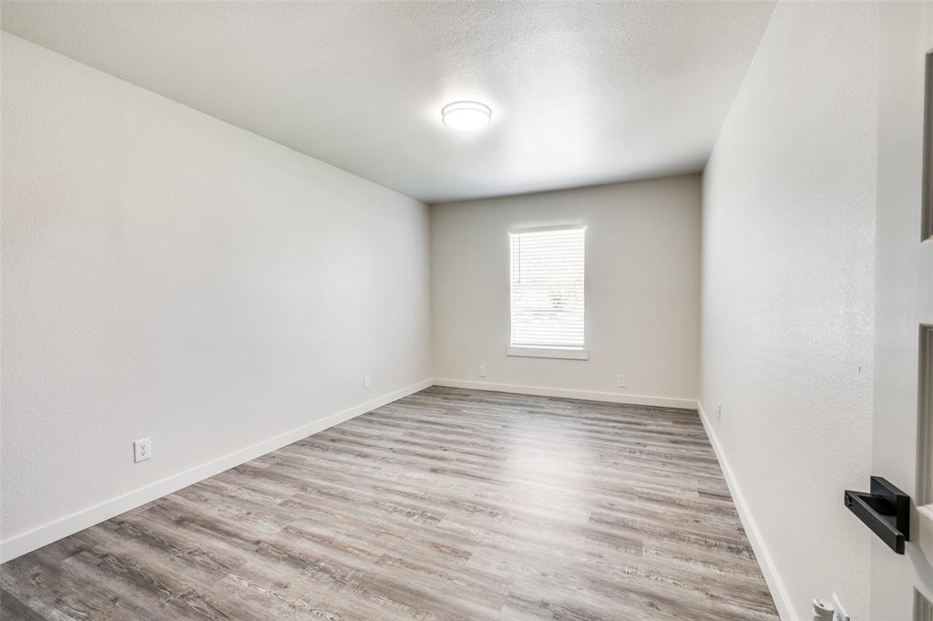 733 Southeast 3rd Street Grand Prairie, TX 75051 - Photo 14 of 24 Spare room with light wood-type flooring and a textured ceiling
