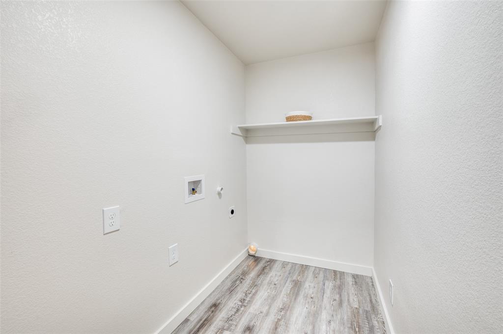 733 Southeast 3rd Street Grand Prairie, TX 75051 - Photo 19 of 24 Laundry room with wood finished floors, hookup for an electric dryer, hookup for a washing machine, hookup for a gas dryer, and a textured wall