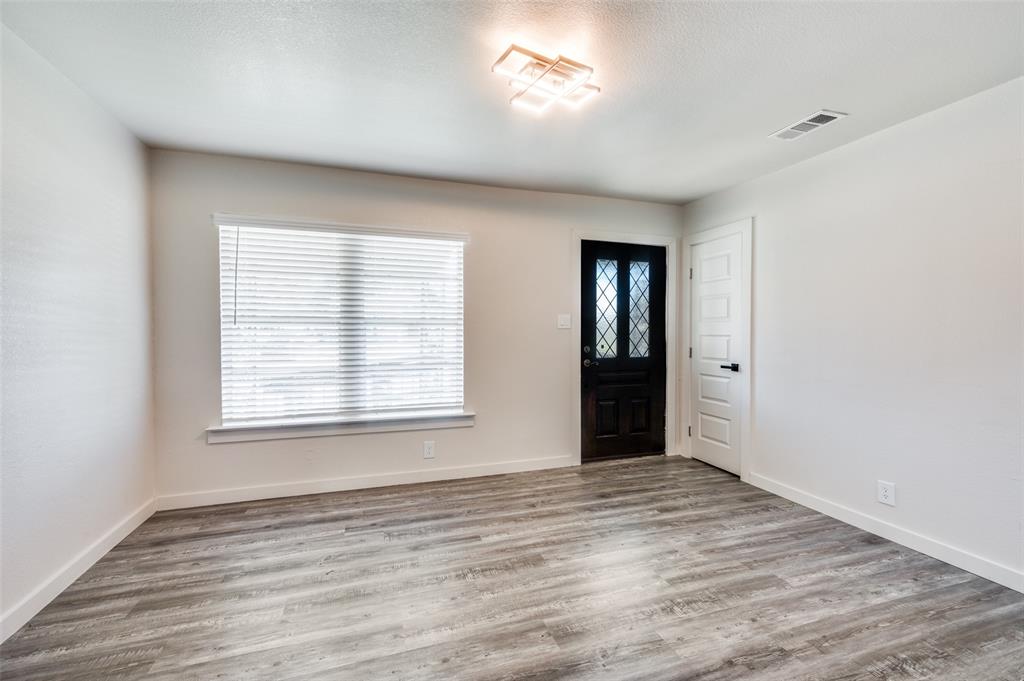 733 Southeast 3rd Street Grand Prairie, TX 75051 - Photo 3 of 24 Entrance foyer featuring wood finished floors and a textured ceiling