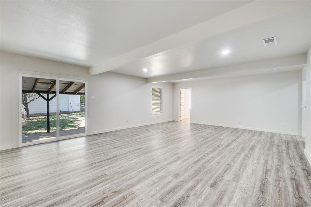 733 Southeast 3rd Street Grand Prairie, TX 75051 - Photo 4 of 24 Spare room featuring light wood finished floors, beam ceiling, and recessed lighting
