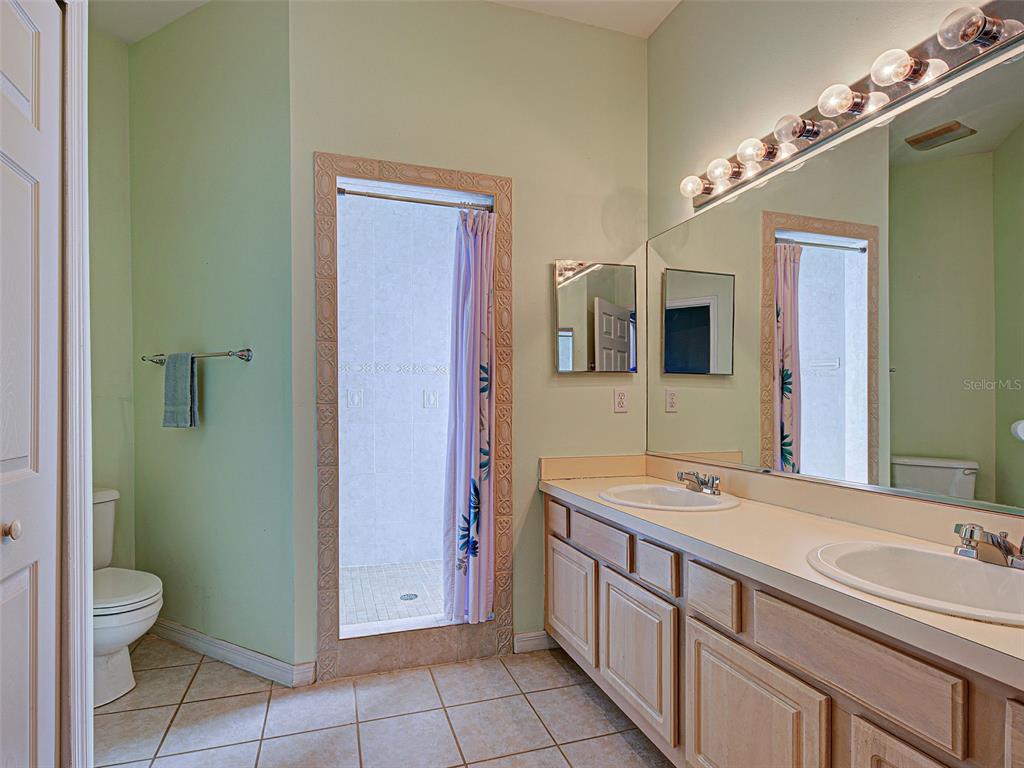 1801 Highland Road Osprey, FL 34229 - Photo 22 of 40 a bathroom with a sink a toilet and mirror