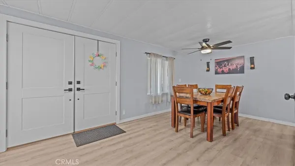 a view of a dining room with furniture and a chandelier fan