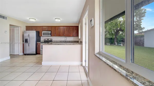 a kitchen with stainless steel appliances granite countertop a refrigerator and a sink