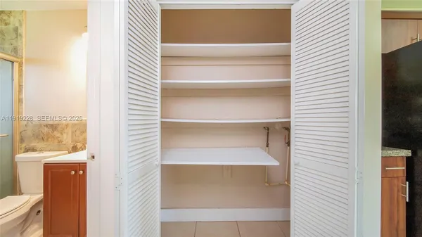 a view of walk in closet with empty racks