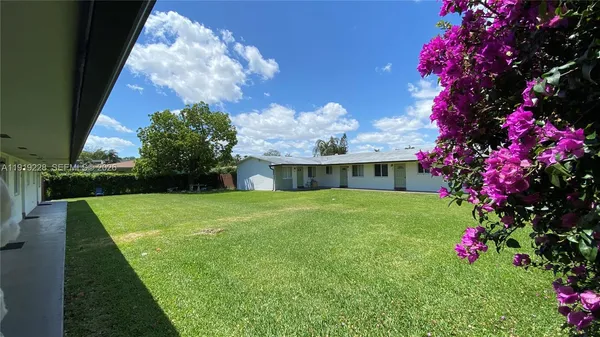 a front view of a house with a yard and fountain