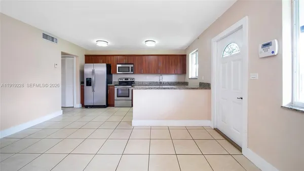 a kitchen with stainless steel appliances granite countertop a refrigerator and a stove top oven
