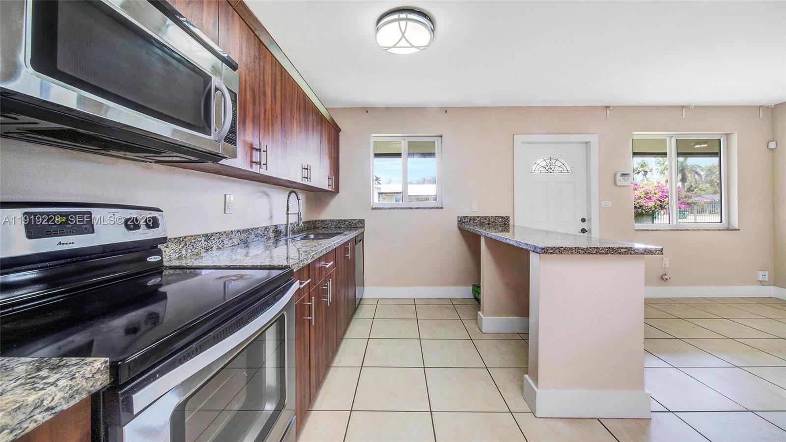 592 Northeast 150th Street, Unit 3 Miami, FL 33161 - Photo 9 of 22 a kitchen with stainless steel appliances granite countertop a sink and a stove