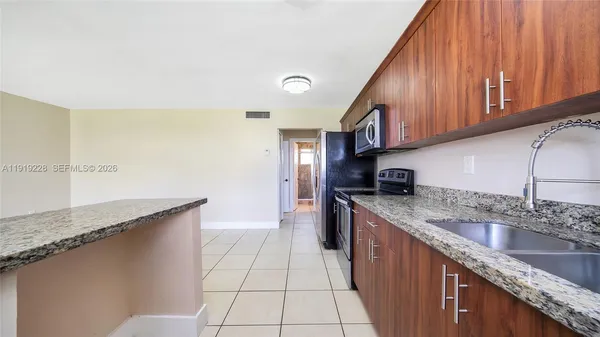 a kitchen with stainless steel appliances granite countertop a sink stove and cabinets