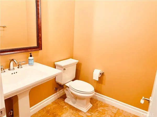a white toilet sitting next to a bathroom sink