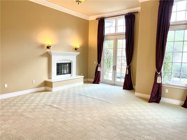 a view of an empty room with a fireplace and a window