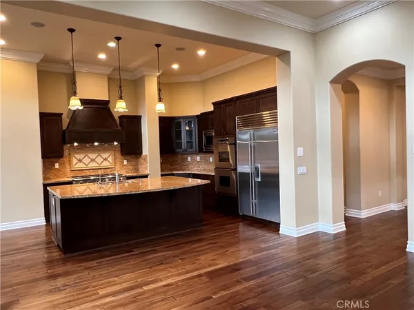 a view of kitchen with stainless steel appliances granite countertop a sink and a refrigerator