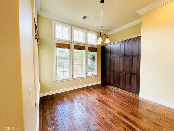 a view of a room with wooden floor fan and windows