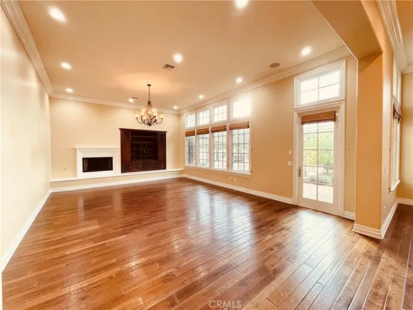 an empty room with wooden floor and fireplace