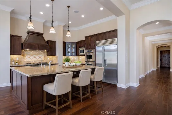 a kitchen with kitchen island granite countertop a sink and a refrigerator
