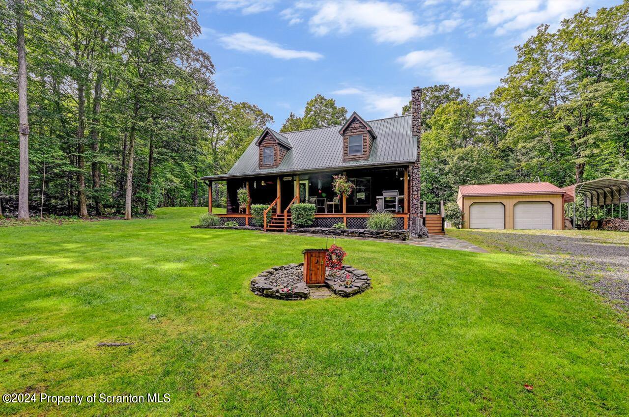 755 Spring Hill Road Sterling, PA 18463 - Photo 1 of 99 a front view of a house with a garden and trees