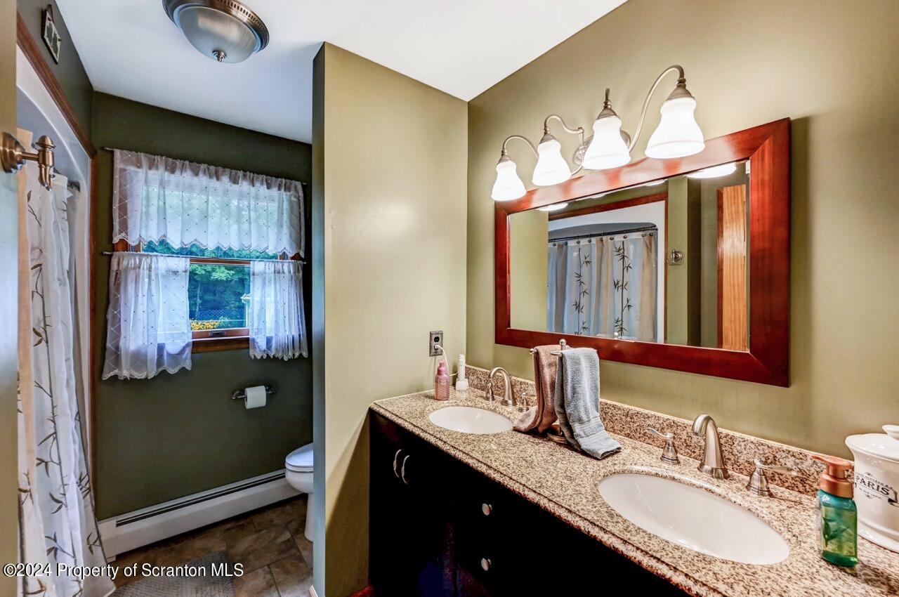 755 Spring Hill Road Sterling, PA 18463 - Photo 27 of 99 a bathroom with a double vanity sink and a mirror