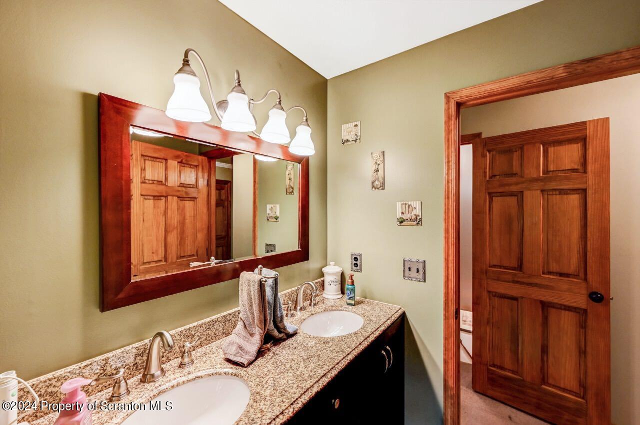 755 Spring Hill Road Sterling, PA 18463 - Photo 28 of 99 a bathroom with a granite countertop double vanity sink and a mirror
