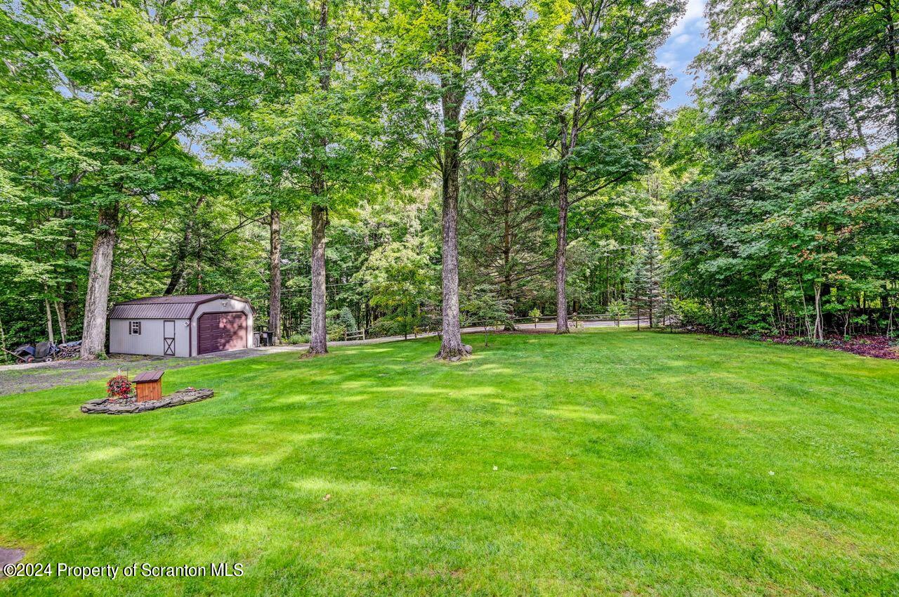 755 Spring Hill Road Sterling, PA 18463 - Photo 80 of 99 a backyard of a house with table and chairs a large tree