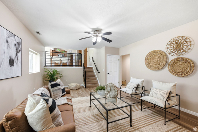 11875 South Elm Ridge Road Sandy, UT 84094 - Photo 23 of 53 Living area featuring wood-finish flooring, a contemporary ceiling fan, and staircase with black metal railing