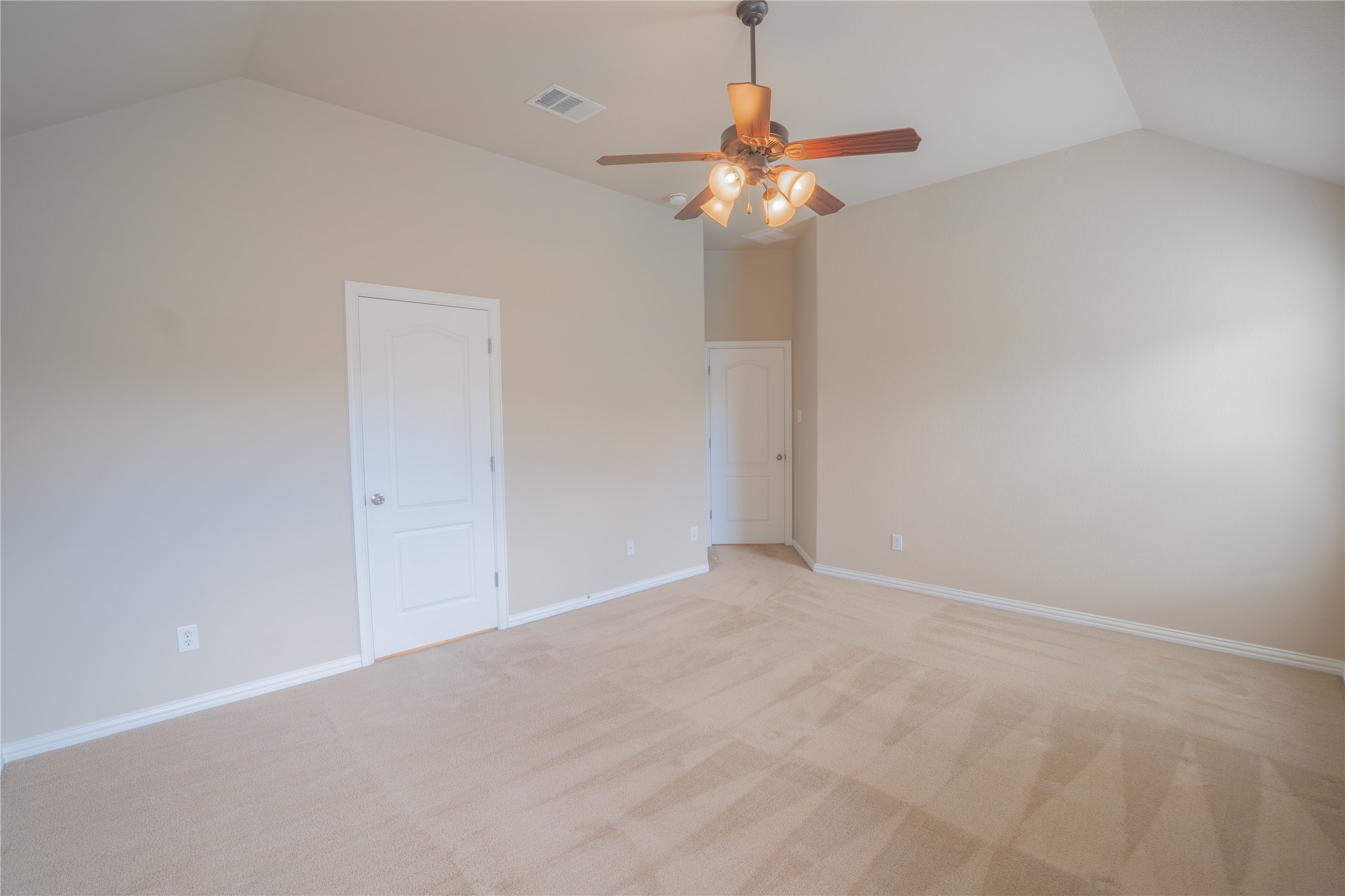 403 Tascate Street Georgetown, TX 78628 - Photo 11 of 26 A comfortable bedroom with high vaulted ceilings and plush carpeting.