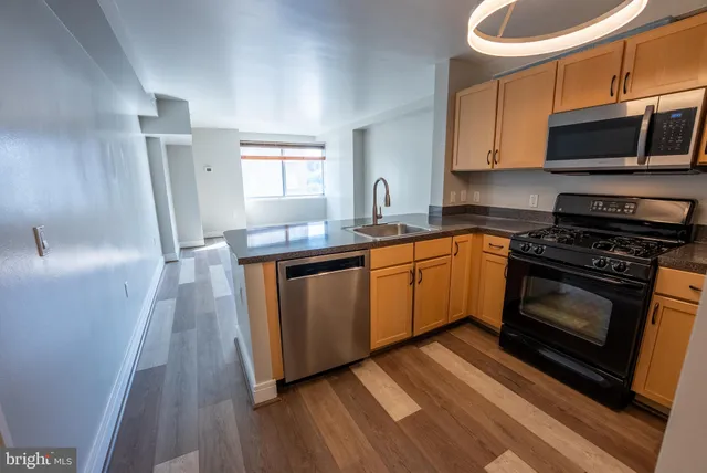 a kitchen with stainless steel appliances a stove a sink and a microwave