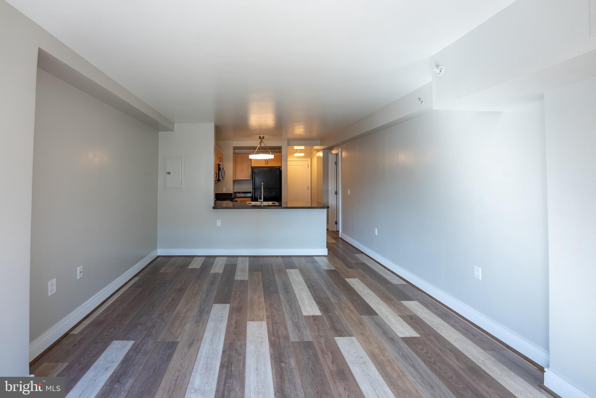 800 4th Street Southwest, Unit N312 Washington, DC 20024 - Photo 5 of 16 a view of a hallway with wooden floor and a kitchen space