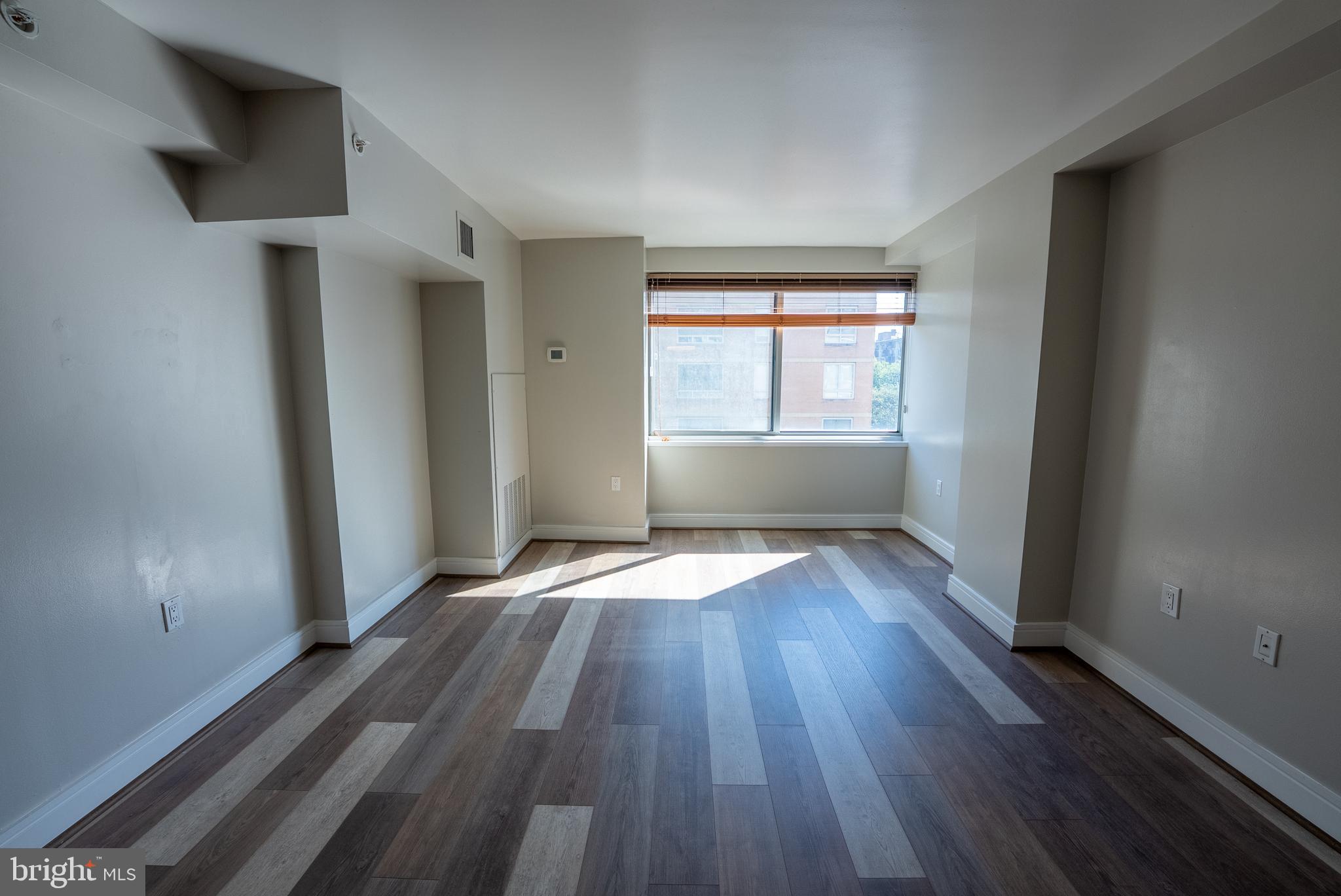 800 4th Street Southwest, Unit N312 Washington, DC 20024 - Photo 6 of 16 an empty room with wooden floor and windows