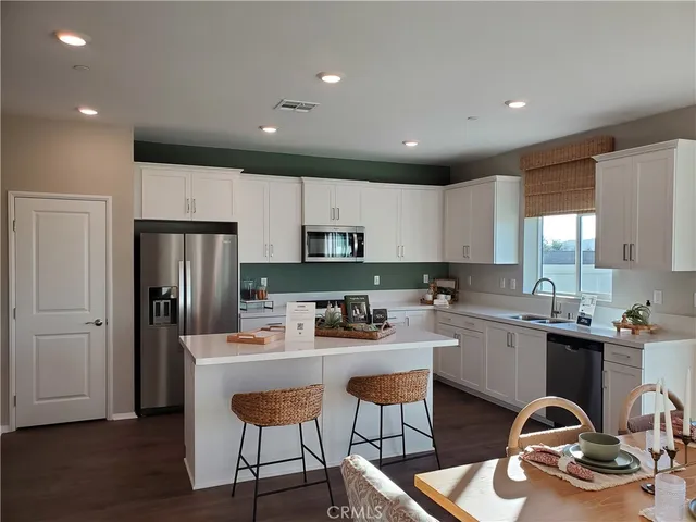a kitchen with a sink a refrigerator and wooden cabinets