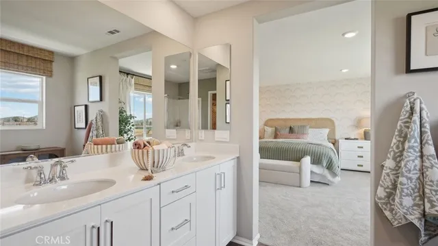 a en suite bathroom with a double vanity sink and a mirror