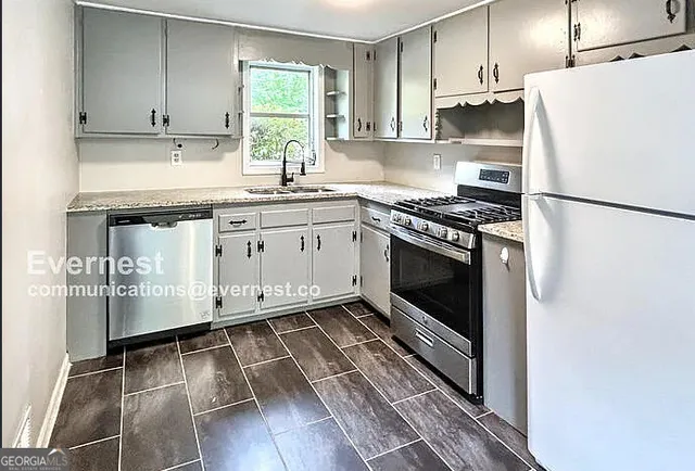 a kitchen with cabinets appliances and a window
