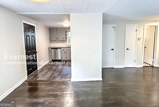 a view of a hallway with wooden floor and a living room