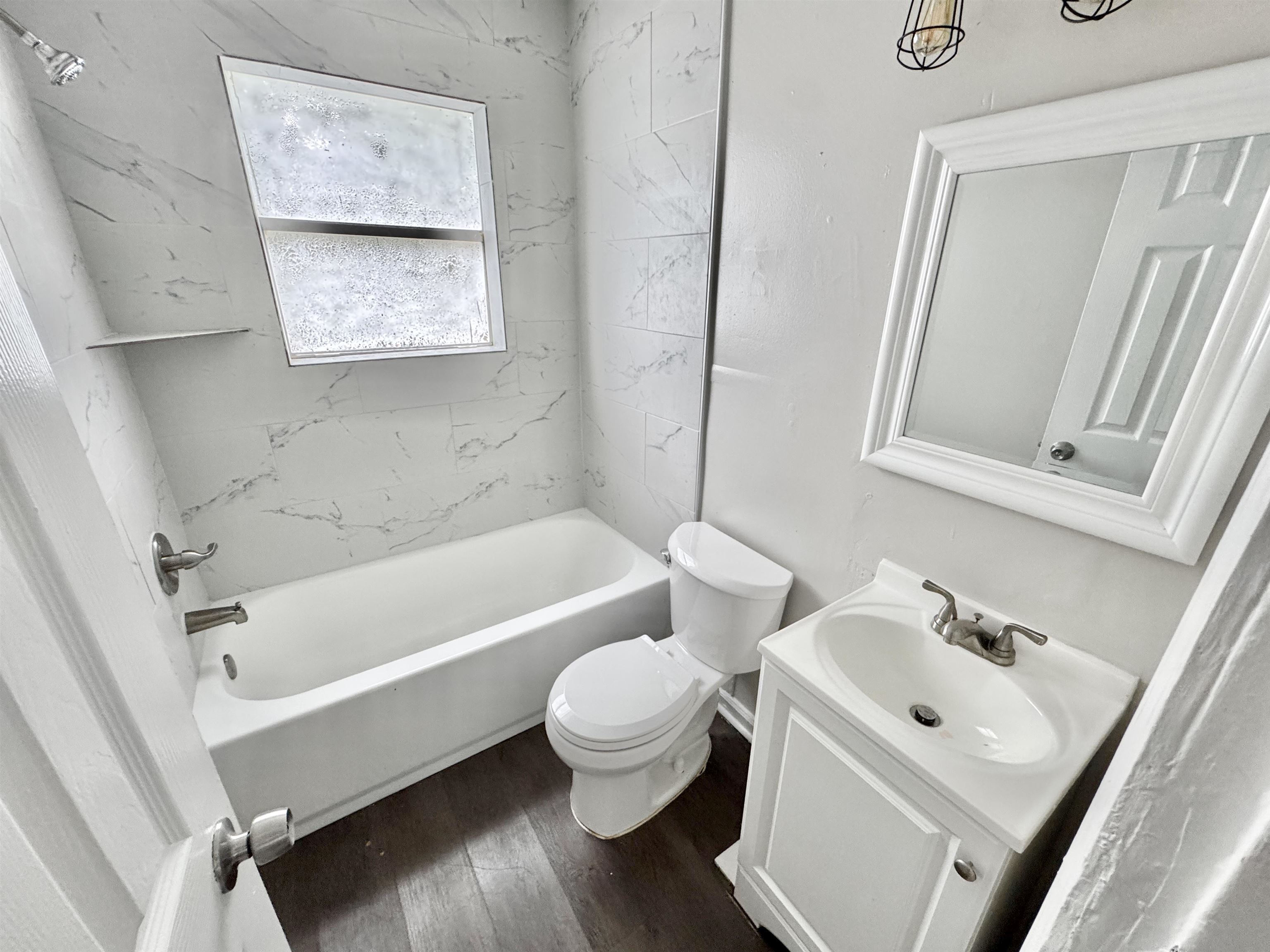 1825 Castalia Street Memphis, TN 38114 - Photo 19 of 30 a bathroom with a white tub sink and mirror