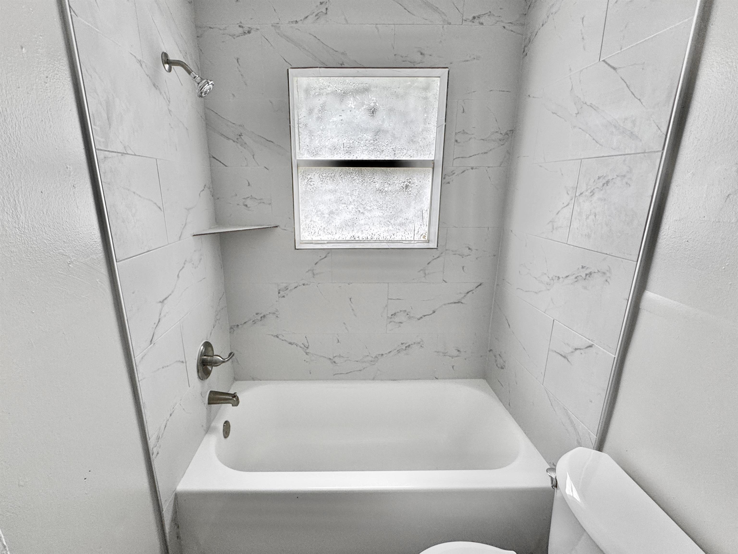 1825 Castalia Street Memphis, TN 38114 - Photo 20 of 30 a bathroom with a bathtub and window