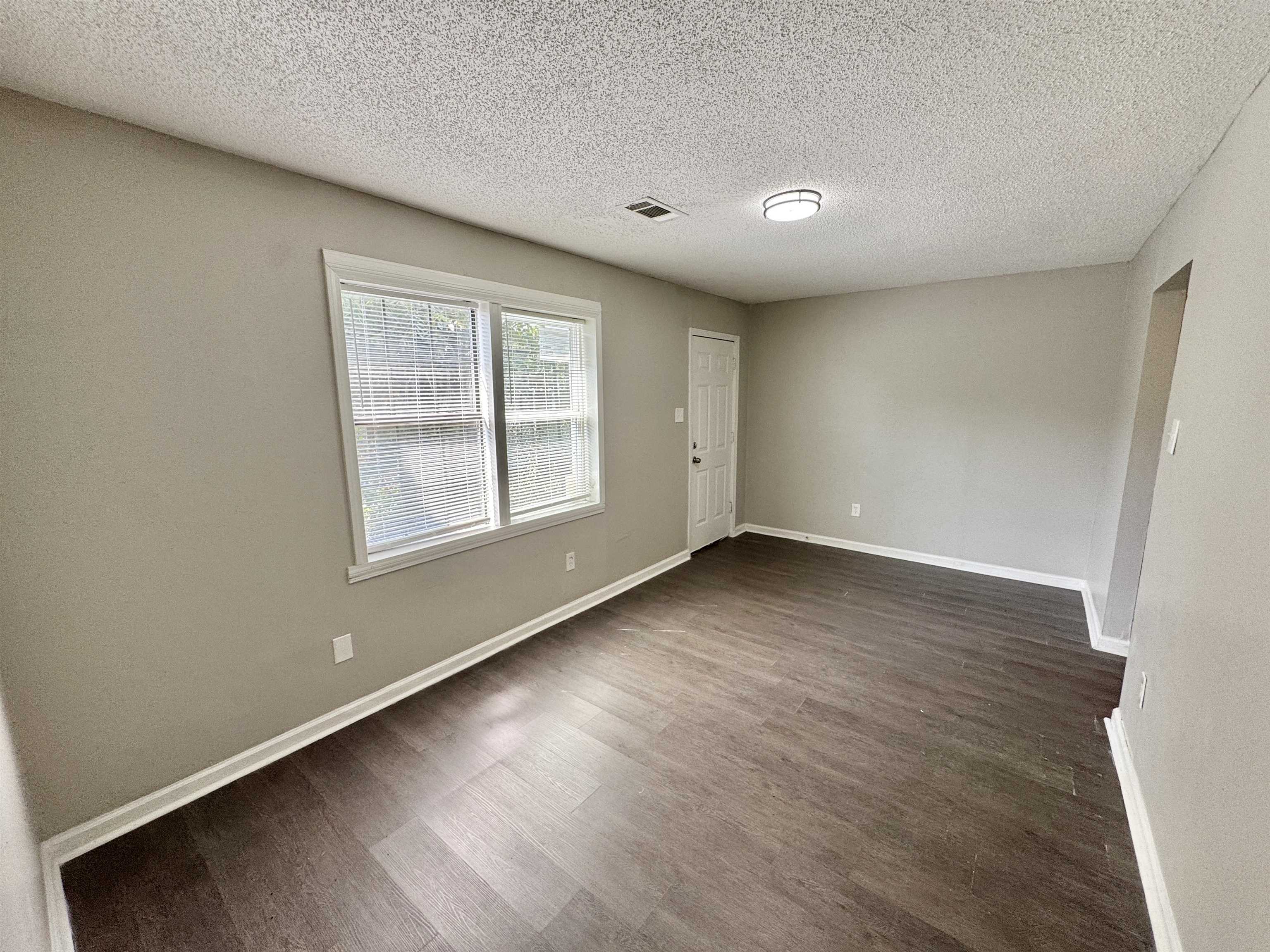 1825 Castalia Street Memphis, TN 38114 - Photo 23 of 30 an empty room with wooden floor and windows