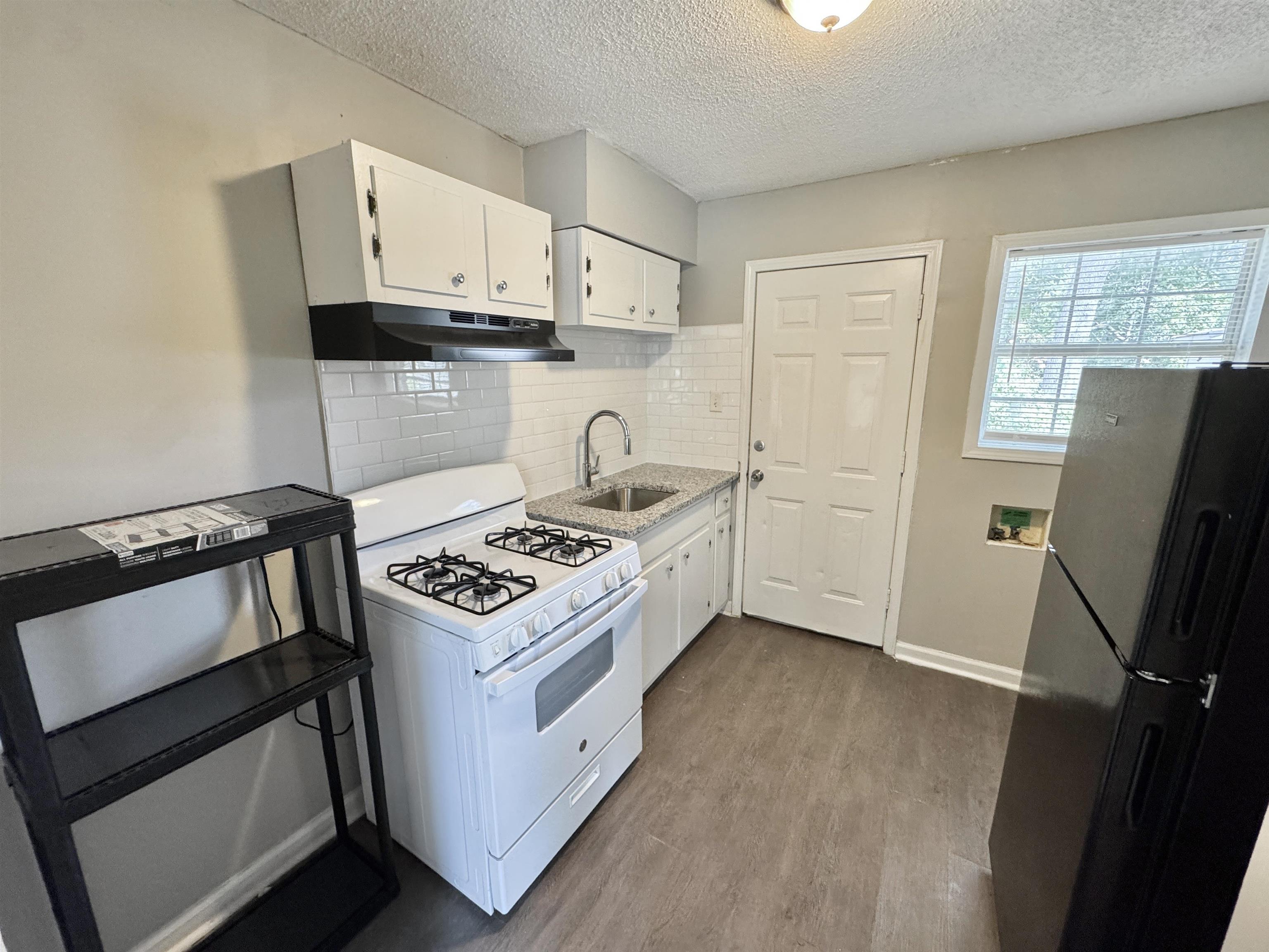 1825 Castalia Street Memphis, TN 38114 - Photo 24 of 30 a kitchen with white cabinets and appliances