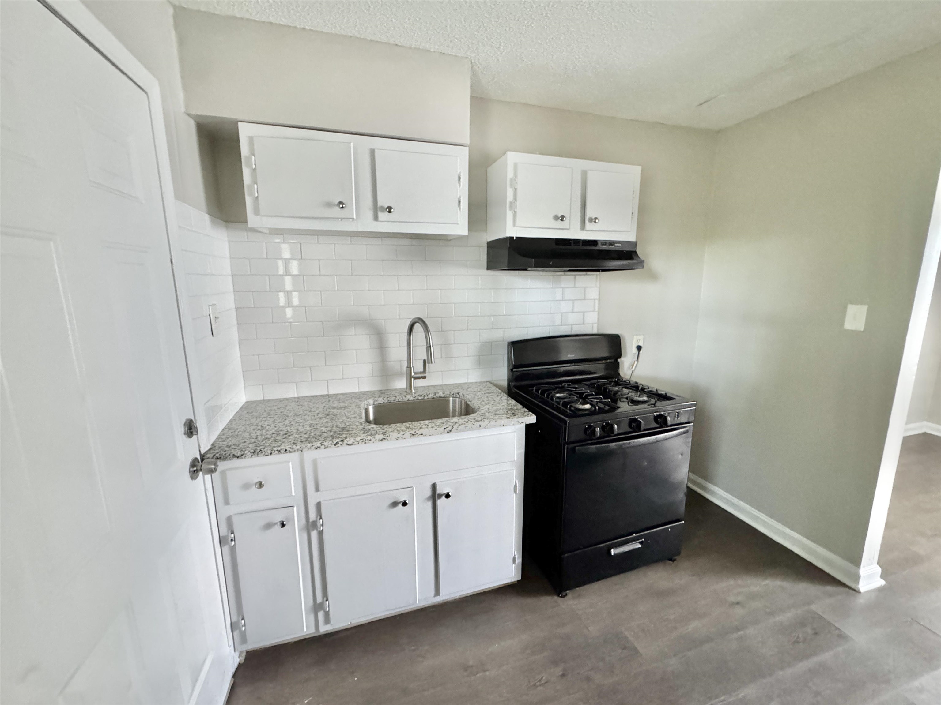 1825 Castalia Street Memphis, TN 38114 - Photo 4 of 30 a kitchen with stainless steel appliances granite countertop white cabinets and a stove