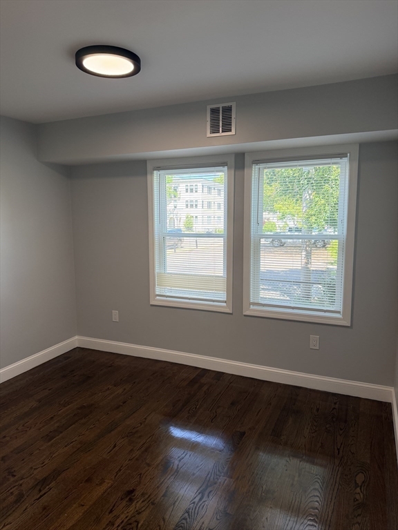 60-62 Wellsmere Road, Unit 1 Boston, MA 02131 - Photo 8 of 19 an empty room with wooden floor and windows