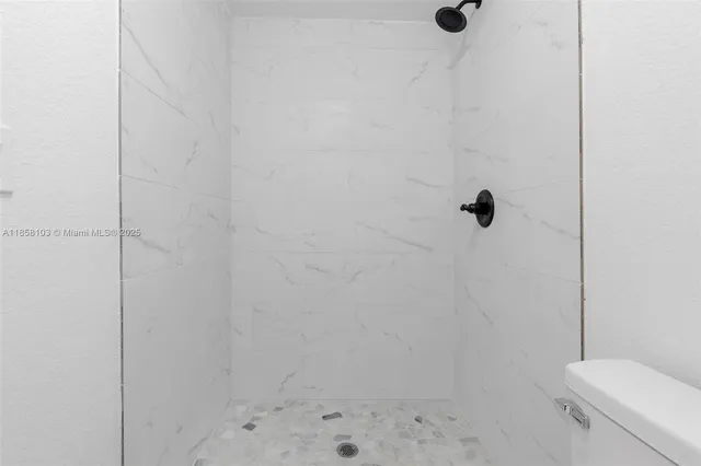 a bathroom with a shower toilet and a window