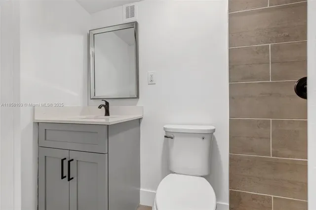 a bathroom with a toilet sink shower and mirror