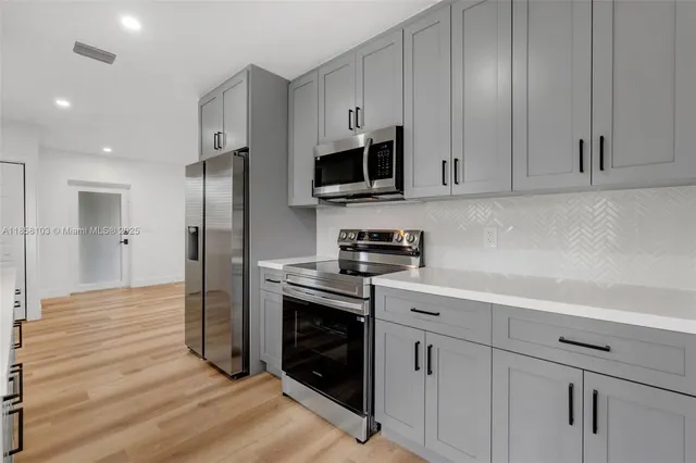 a spacious bathroom with a granite countertop sink a mirror and a shower