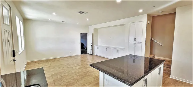 a kitchen with stainless steel appliances granite countertop a sink a stove a refrigerator a washer and dryer