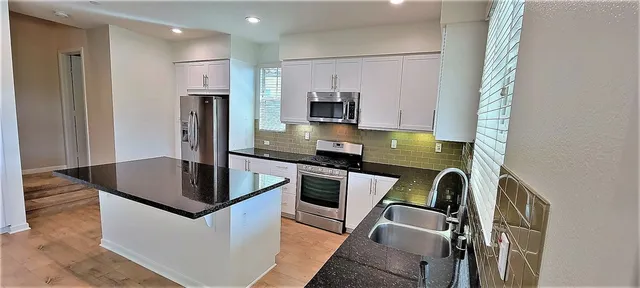a kitchen with a refrigerator a stove and a sink