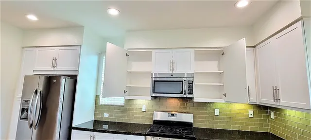 a kitchen with stainless steel appliances granite countertop a stove and a refrigerator