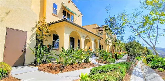 a view of a white house with a flower plants