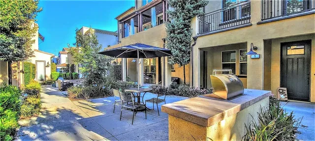 a patio with a table and chairs under an umbrella