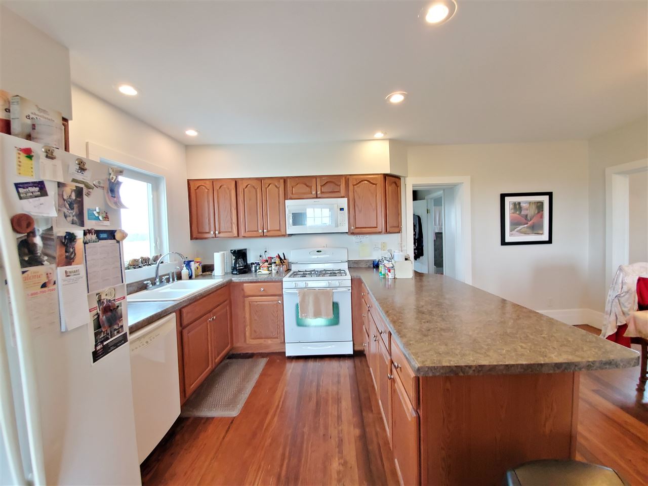9700 West Edgewood Road Dixon, IL 61021 - Photo 9 of 36 a kitchen with stainless steel appliances granite countertop a refrigerator a sink dishwasher a stove and white countertops with wooden floor
